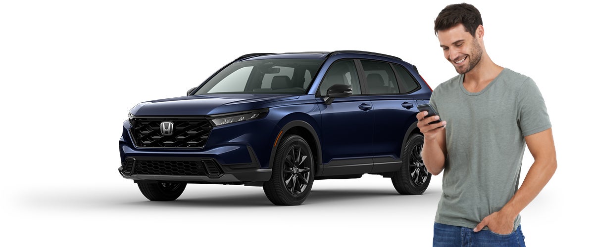 Man standing infront of a honda on his phone