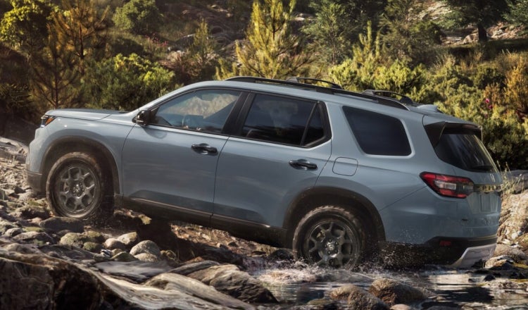 Blue SUV driving up rocky terrain